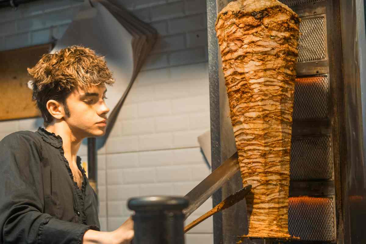 un ragazzo che sta preparando il kebab
